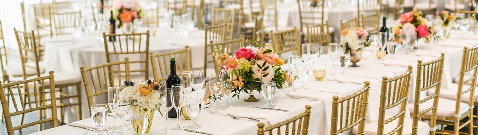 Wedding reception setup with gold chiavari chairs and floral centerpieces